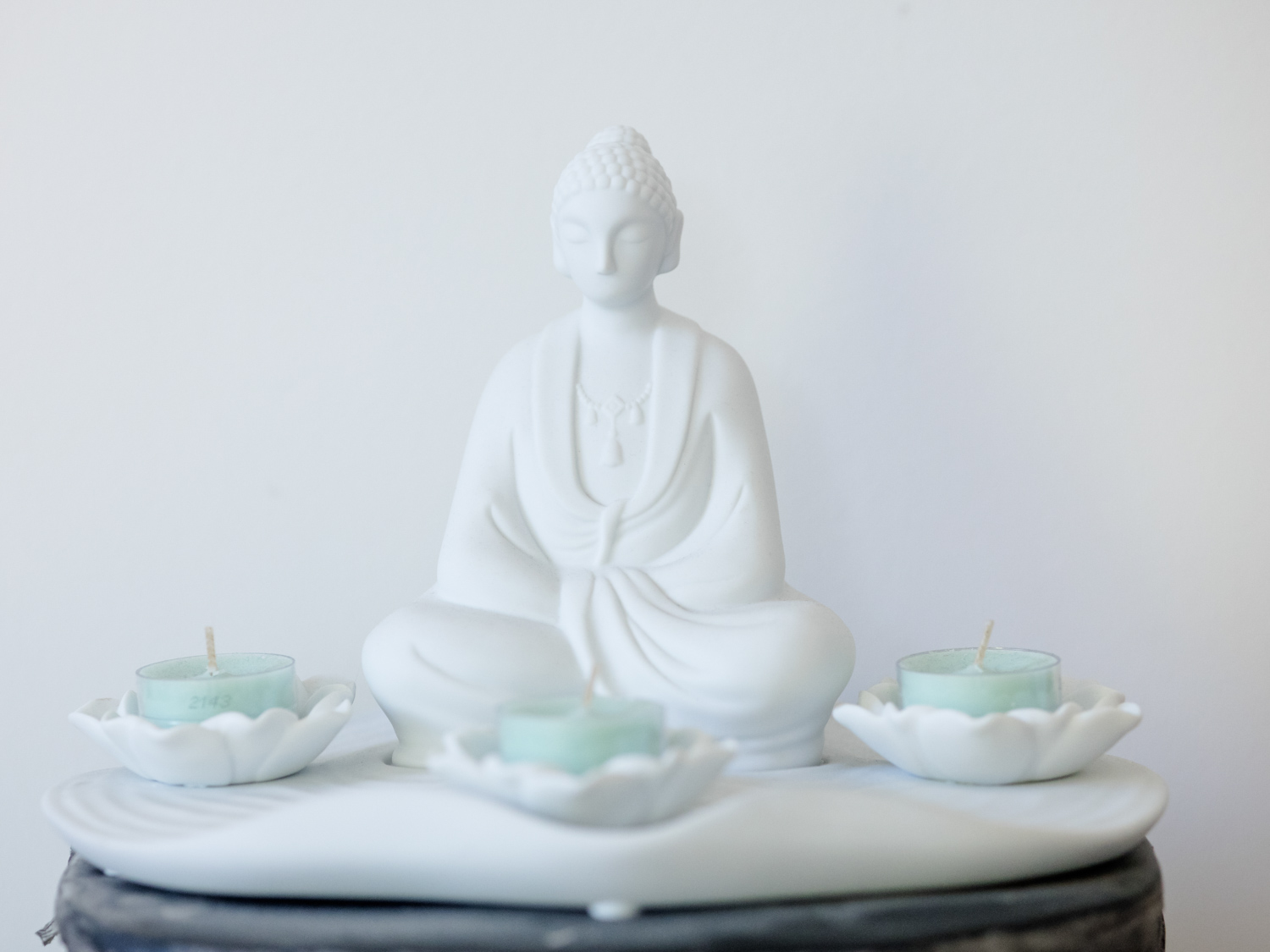 Ruhiger Behandlungsraum mit Buddha-Figur und Kerzen
